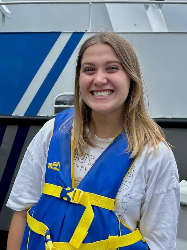 Anna Maki stands dockside next to the R/V W.G. Jackson